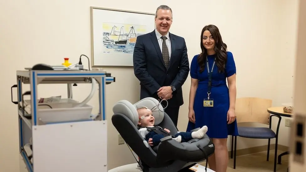 University of Michigan researchers and engineers with the specialized rotational chair for infants