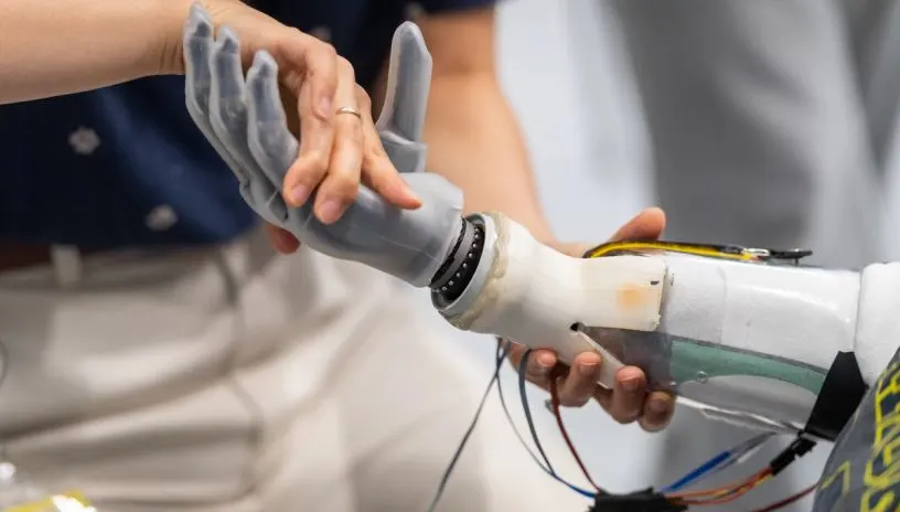 A person adjusting a robotic hand