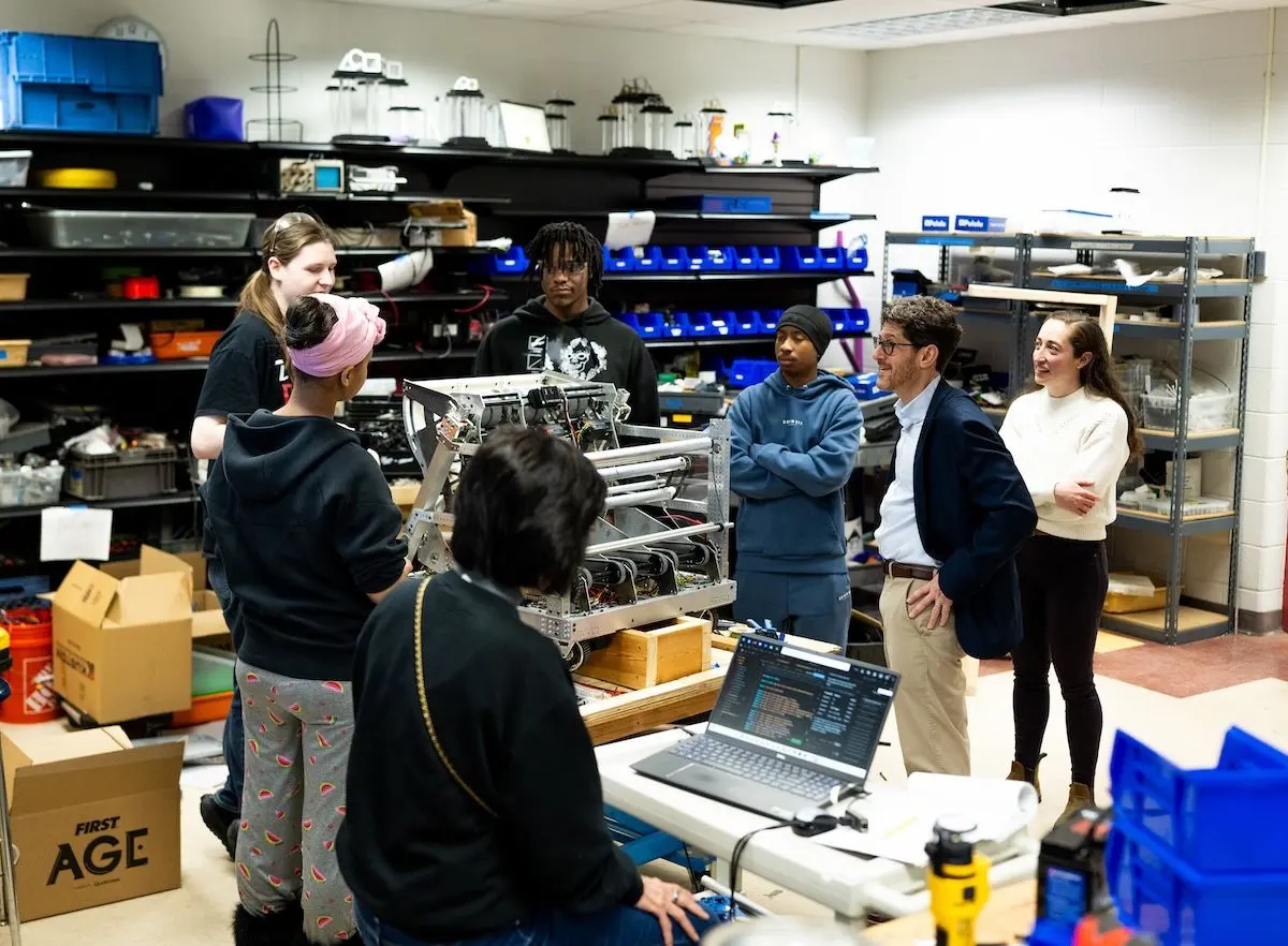 Youth Policy Lab researchers working with students in a room full of CTE equipment