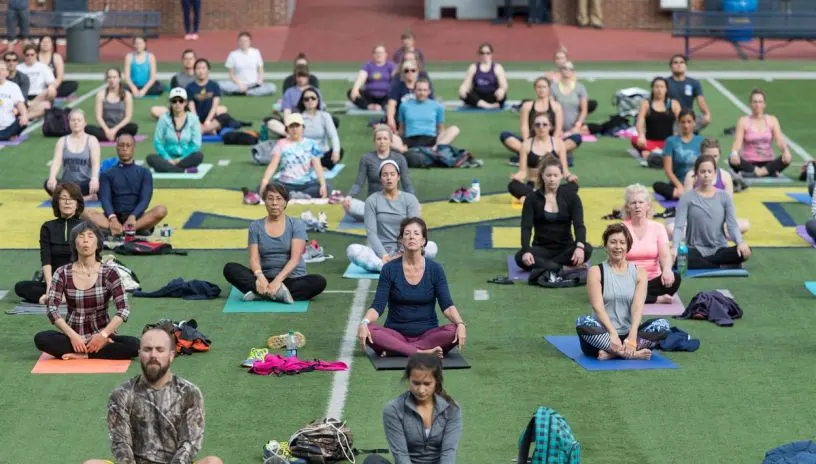 People doing yoga on the field at the Big House