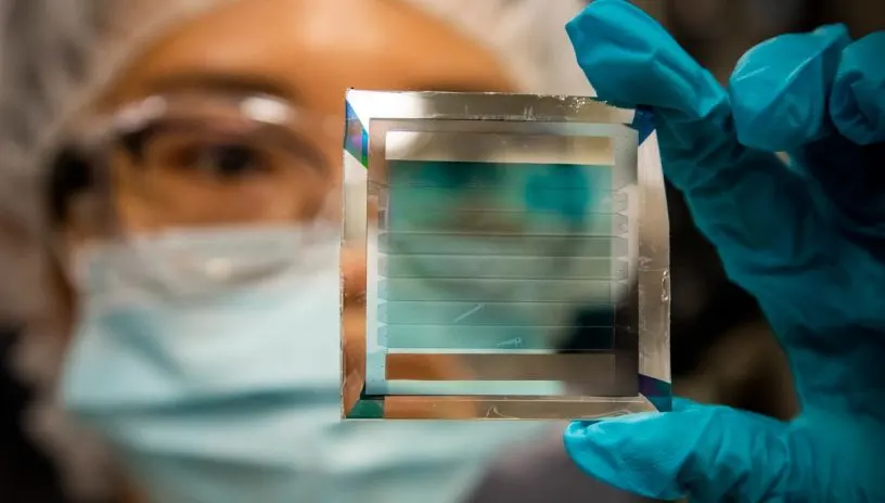 Researcher in scrubs looks closely at screen