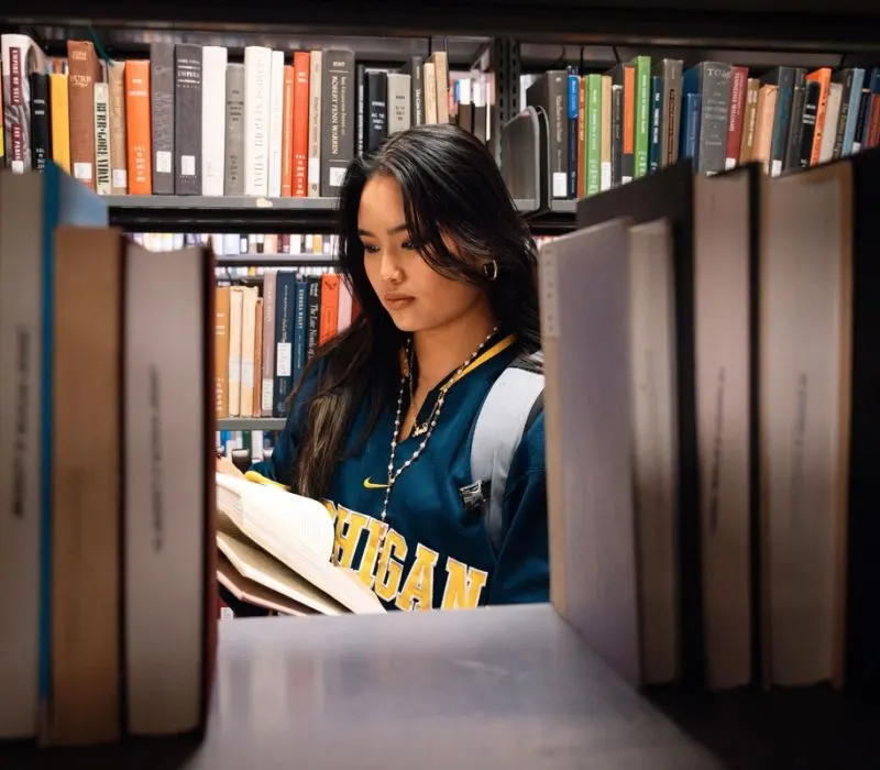 A student reads a book in a library