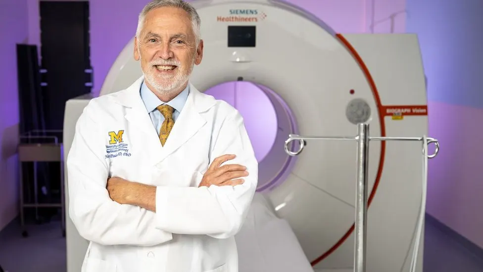 Henry Paulson, M.D., Ph.D. in front of an MRI machine