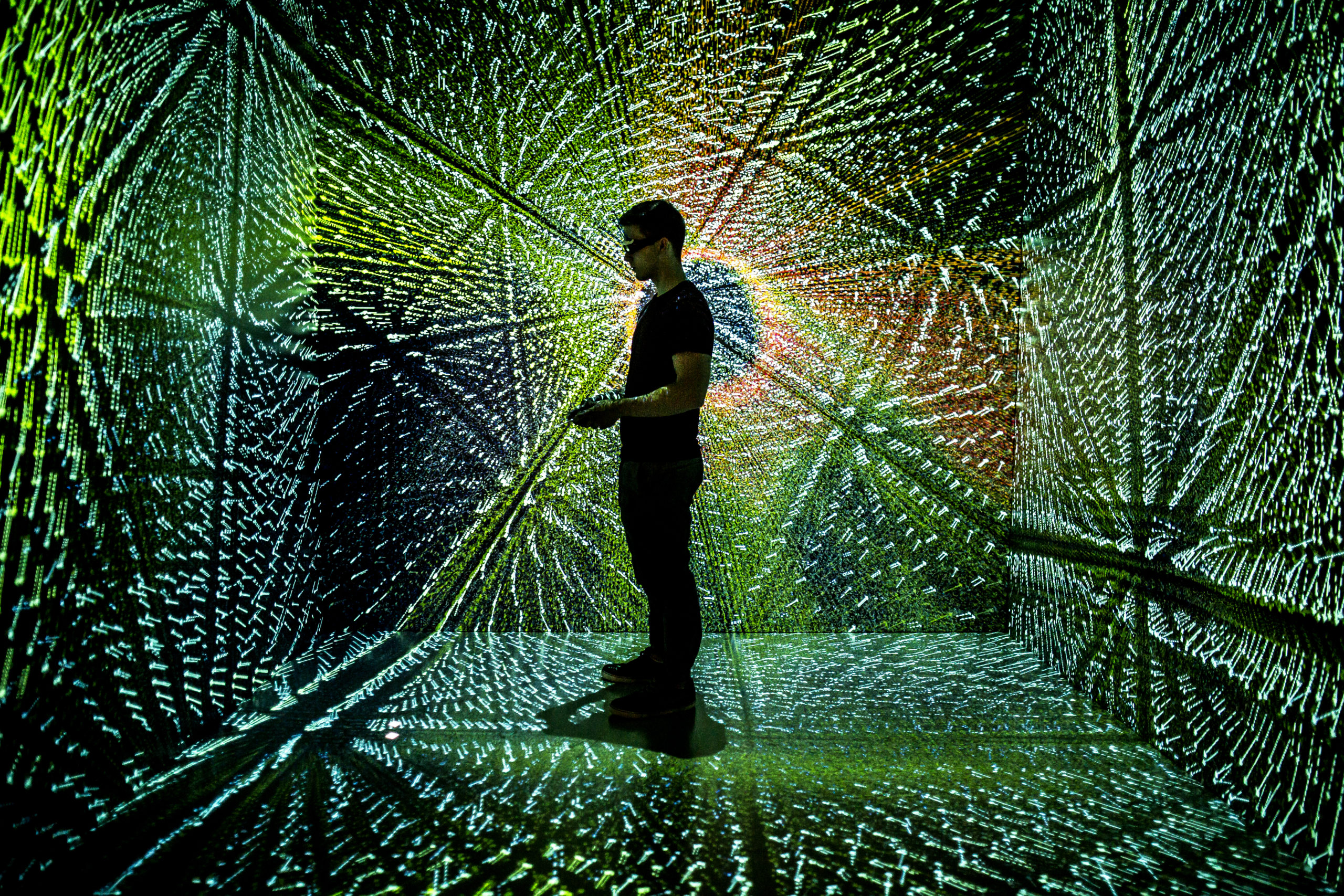 Engineering student runs simulation with bright colorful lights surround him